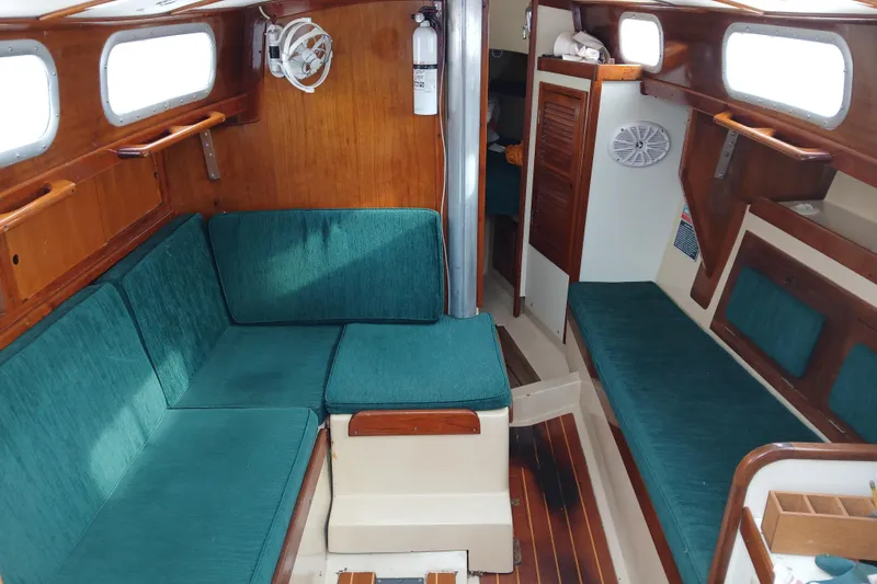 Slide: The Image of Interior of a 1974 Tartan 30 sailboat with teal seating and wooden accents. - 5
