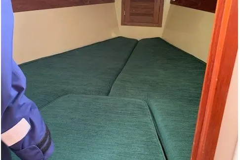 Slide: The Image of 1974 Tartan 30 sailboat interior with green cushions and wooden accents. - 9