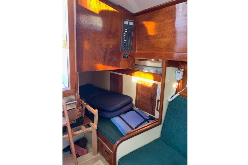 Slide: The Image of 1974 Tartan 30 sailboat interior with wooden cabinetry and green seating. - 7