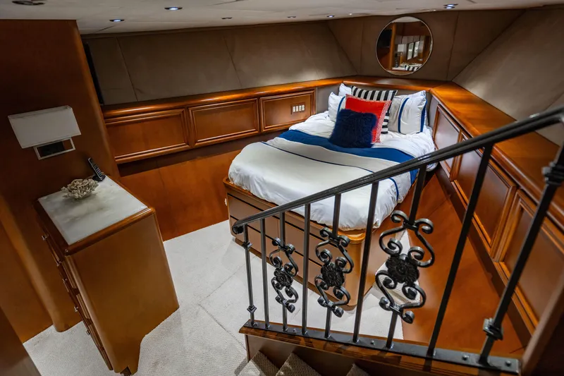 Slide: The Image of Luxurious 2006 Broward Raised Pilothouse yacht bedroom with elegant wood paneling and plush bedding. - 18