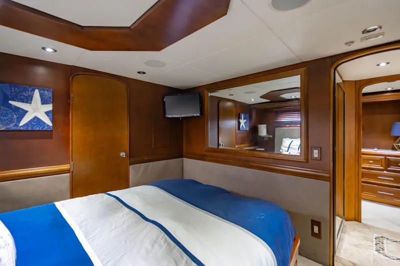 Slide: The Image of Luxurious 2006 Broward Raised Pilothouse yacht bedroom with elegant wood paneling and nautical decor. - 23