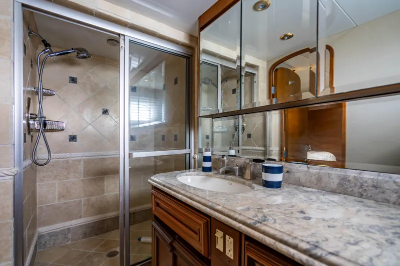 Slide: The Image of Luxurious bathroom in 2006 Broward Raised Pilothouse yacht with marble countertop and glass shower. - 24