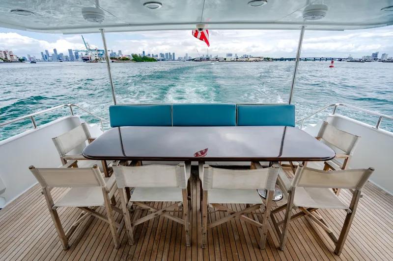 Slide: The Image of Luxury yacht deck with dining area, Broward Raised Pilothouse, 2006, cruising on open water. - 36