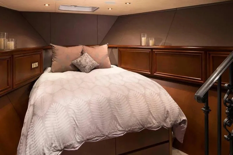 Slide: The Image of Luxurious bedroom interior in 2006 Broward Raised Pilothouse yacht, featuring elegant bedding and wood paneling. - 9