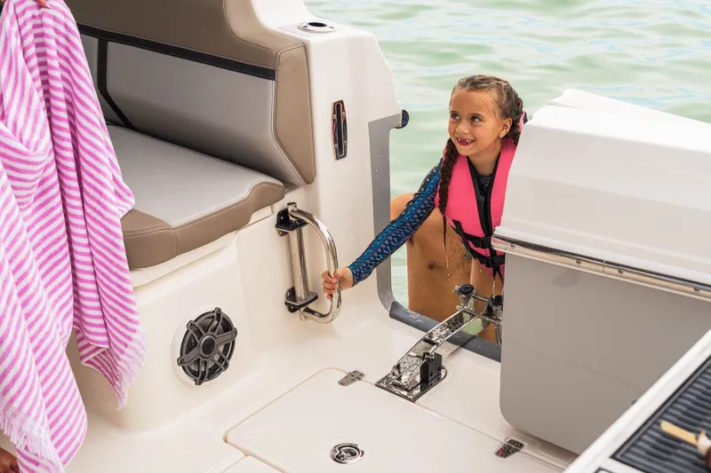 Slide: The Image of A child in a life jacket climbs onto a boat. A towel hangs nearby. - 12