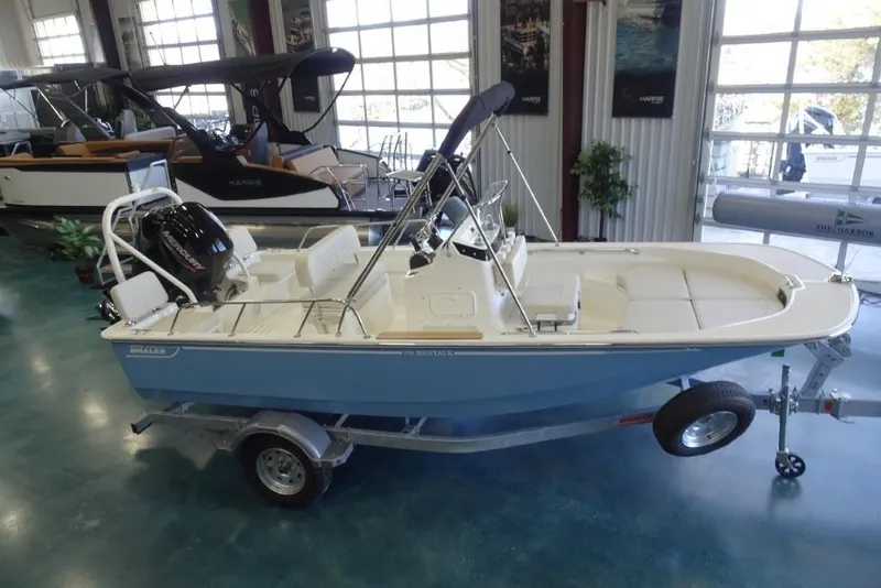 Slide: The Image of 2026 Boston Whaler 170 Montauk boat on trailer in showroom setting. - 2