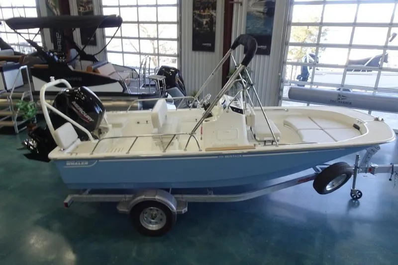 Slide: The Image of 2026 Boston Whaler 170 Montauk boat on trailer in showroom setting. - 3