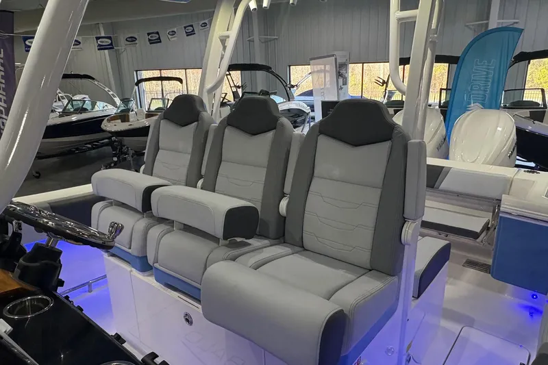 Slide: The Image of 2026 Robalo R300 Center Console boat interior with three gray cushioned seats. - 16