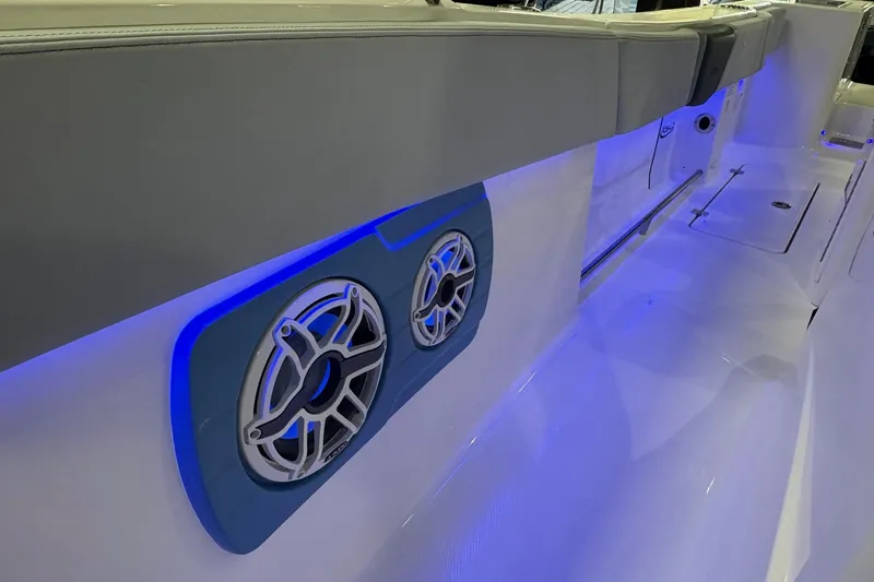 Slide: The Image of 2026 Robalo R300 Center Console boat interior with blue LED lighting and speakers. - 18