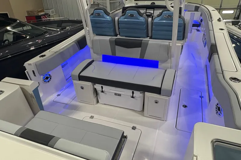 Slide: The Image of 2026 Robalo R300 Center Console boat interior with blue LED lighting and cushioned seating. - 19