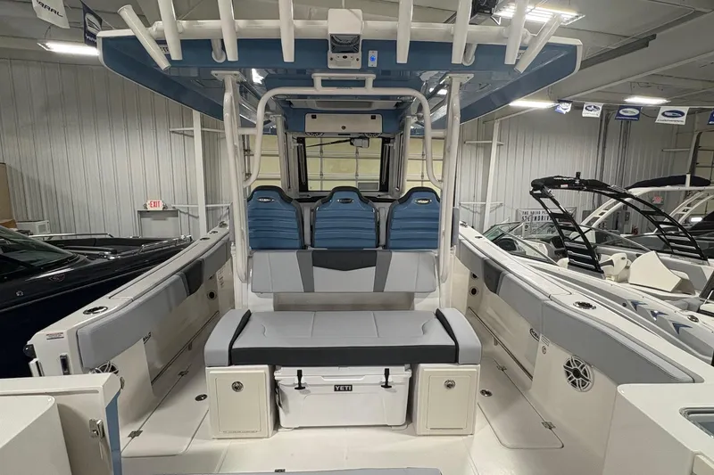 Slide: The Image of 2026 Robalo R300 Center Console boat interior with seating and storage in a showroom. - 21