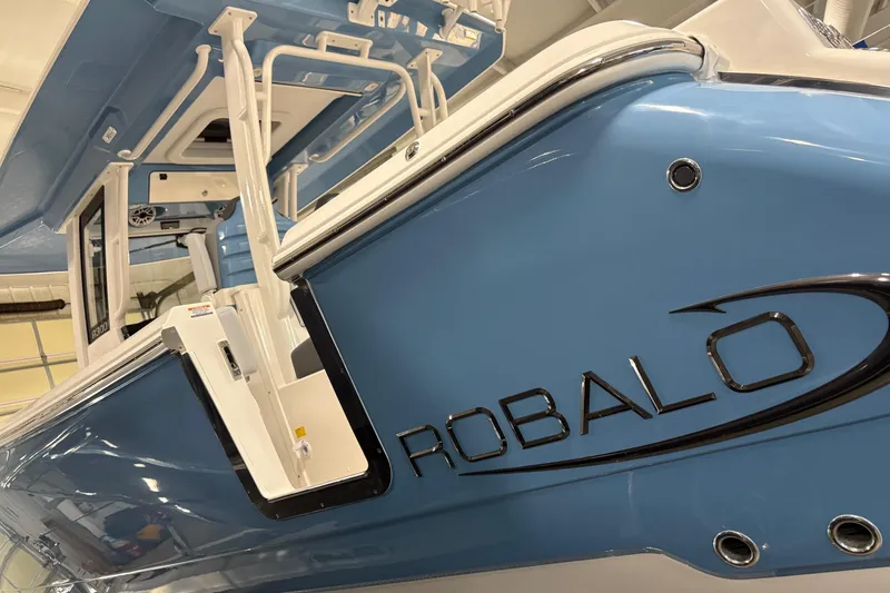 Slide: The Image of 2026 Robalo R300 Center Console boat, blue exterior, close-up view. - 24