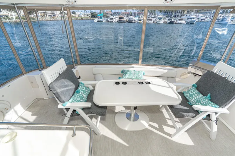 Slide: The Image of 1998 Sea Ray 420 Aft Cabin yacht interior with seating, table, and marina view. - 16