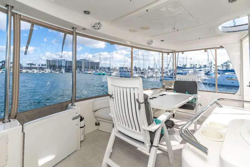 Slide: The Image of 1998 Sea Ray 420 Aft Cabin yacht interior with marina view, featuring seating and table. - 17