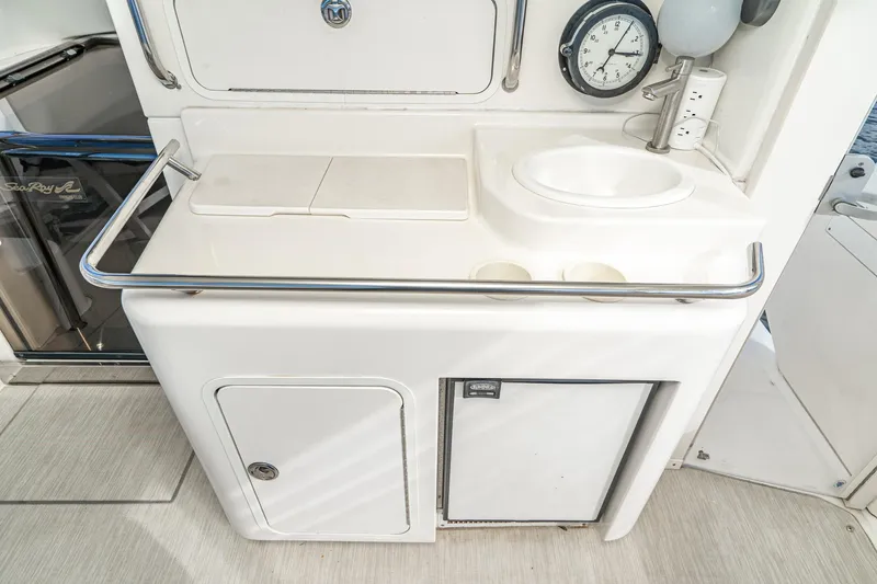 Slide: The Image of 1998 Sea Ray 420 Aft Cabin yacht kitchenette with sink, clock, and storage. - 21