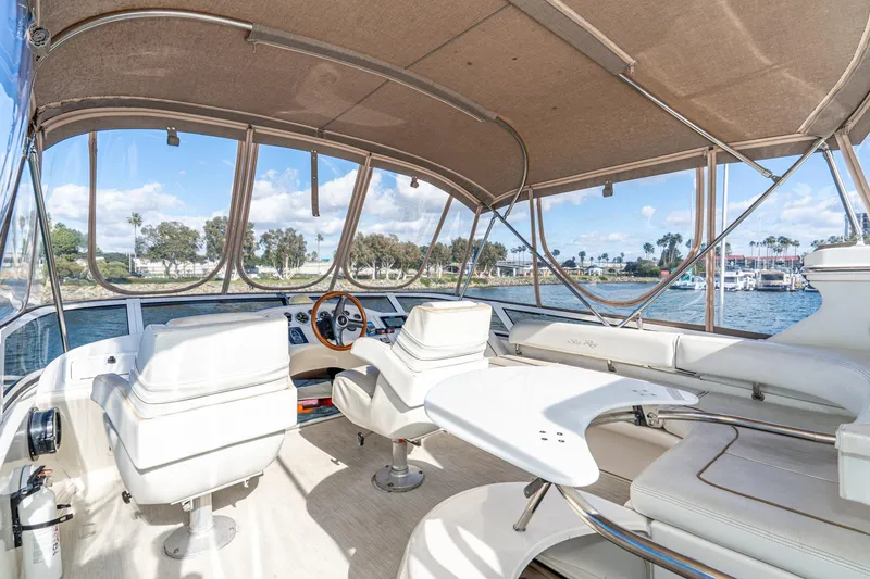 Slide: The Image of 1998 Sea Ray 420 Aft Cabin interior with helm, seating, and waterfront view. - 22