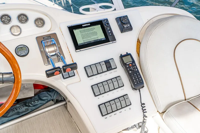 Slide: The Image of 1998 Sea Ray 420 Aft Cabin helm with controls, gauges, and navigation equipment. - 26