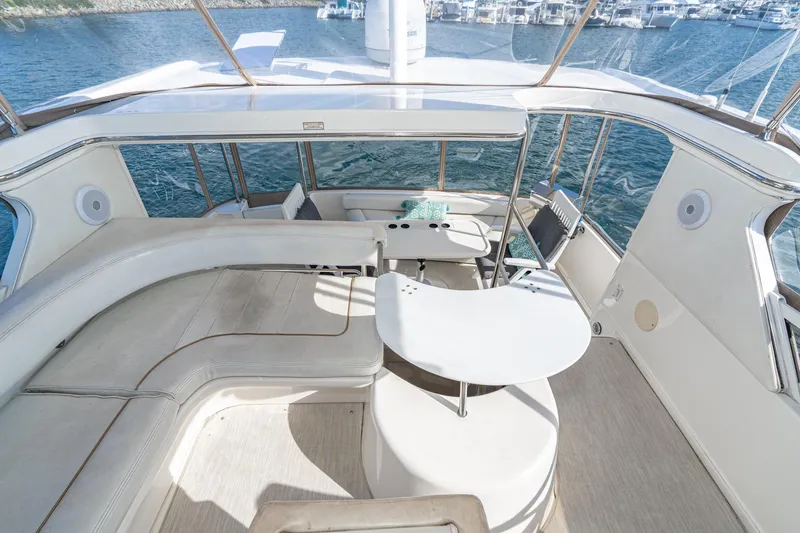 Slide: The Image of 1998 Sea Ray 420 Aft Cabin yacht interior with spacious seating and table, overlooking marina. - 28