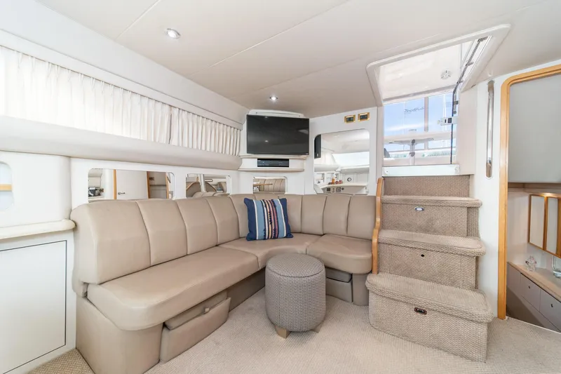 Slide: The Image of 1998 Sea Ray 420 Aft Cabin interior with beige seating, stairs, and TV. - 31