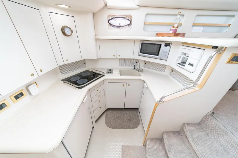 Slide: The Image of 1998 Sea Ray 420 Aft Cabin yacht kitchen with modern appliances and white cabinetry. - 36