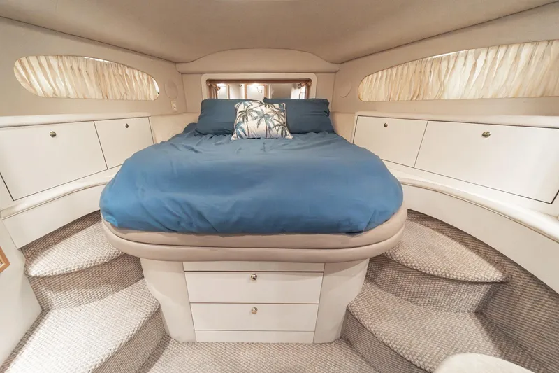 Slide: The Image of Luxurious 1998 Sea Ray 420 Aft Cabin bedroom with blue bedding and elegant design. - 41