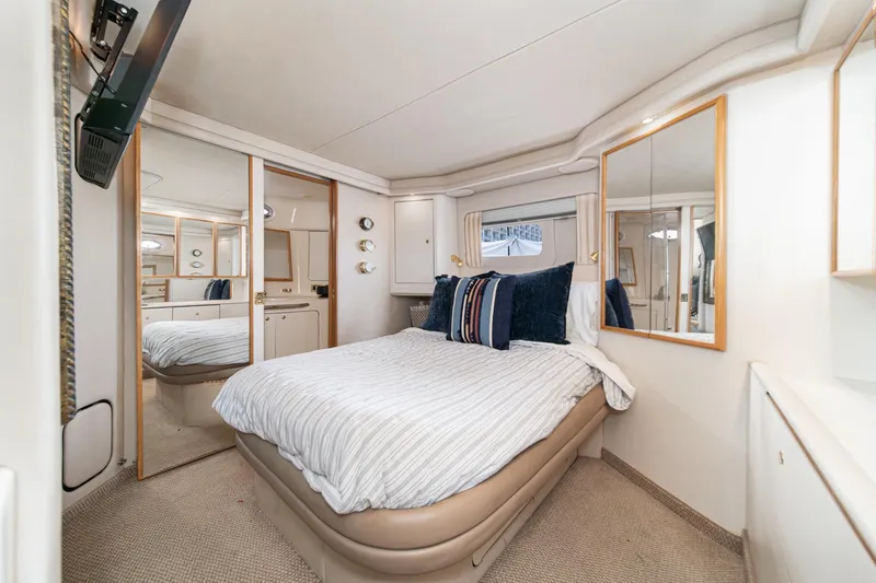 Slide: The Image of Luxurious 1998 Sea Ray 420 Aft Cabin bedroom with elegant decor and mirrored accents. - 44