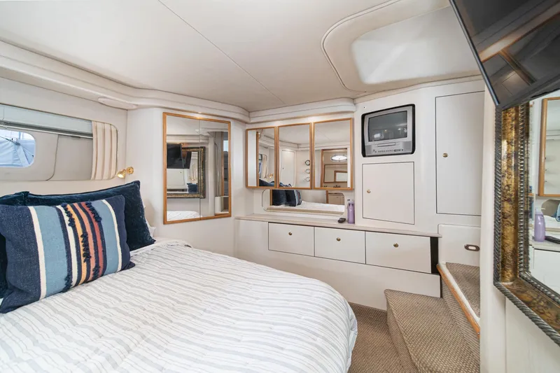 Slide: The Image of Luxurious 1998 Sea Ray 420 Aft Cabin interior with cozy bed and elegant decor. - 45