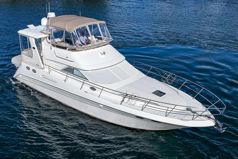 Slide: The Image of 1998 Sea Ray 420 Aft Cabin yacht cruising on blue water. - 8