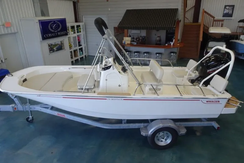 Slide: The Image of 2026 Boston Whaler 170 Montauk boat on trailer in showroom. - 11