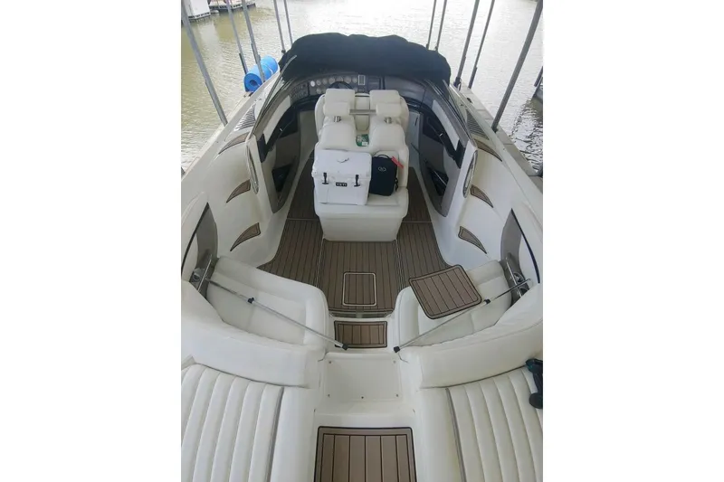 Slide: The Image of 2004 Cobalt 343 boat interior with white seating and wood accents, docked by the water. - 10