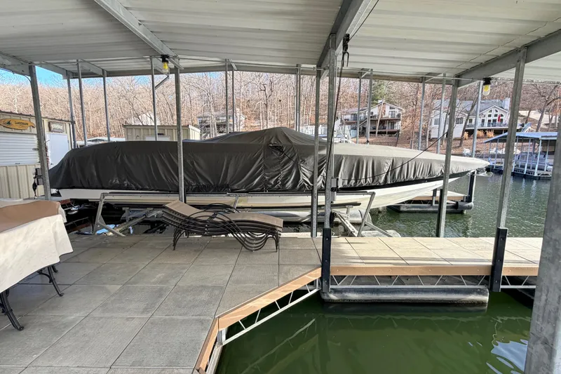 Slide: The Image of Covered 2004 Cobalt 343 boat docked in a marina with surrounding houses. - 13