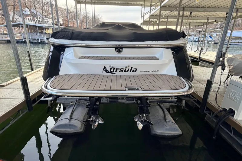 Slide: The Image of 2004 Cobalt 343 boat docked, rear view with covered deck and dual propellers. - 23