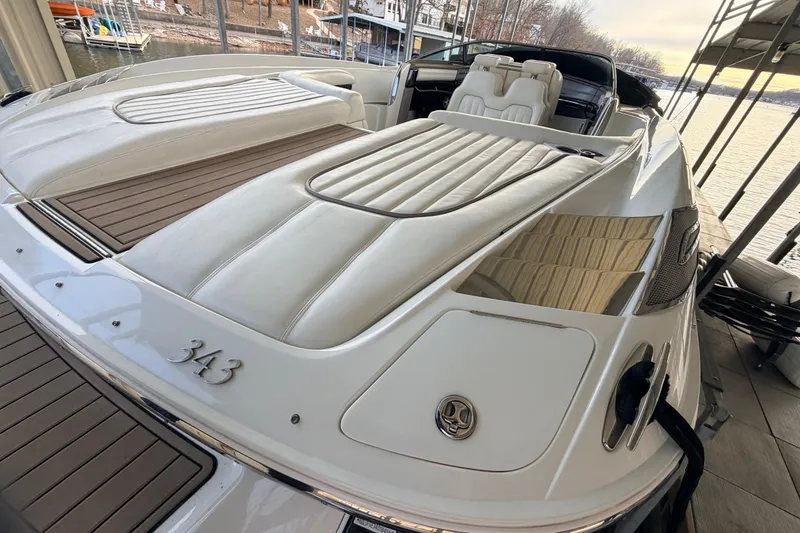 Slide: The Image of 2004 Cobalt 343 boat with white leather seating, docked by a serene lakeside. - 29