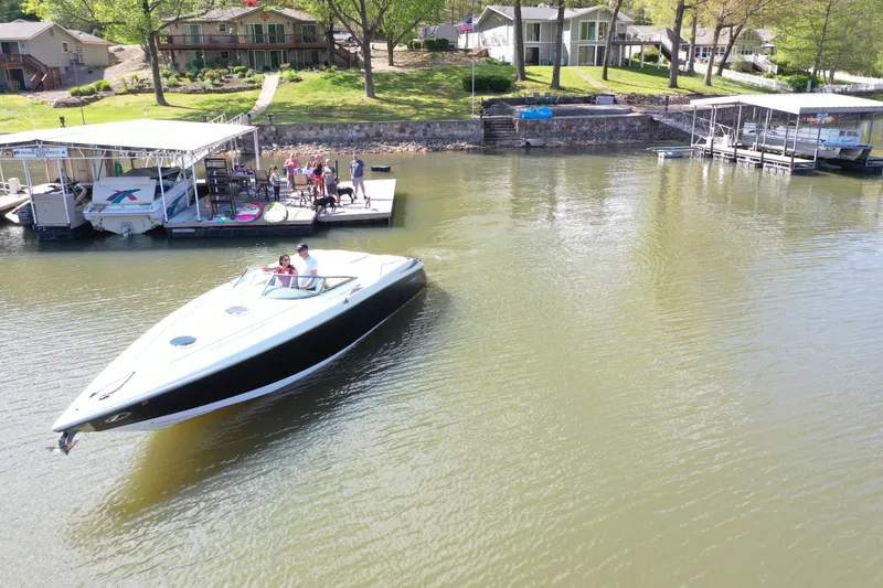 Slide: The Image of 2004 Cobalt 343 boat cruising near lakeside homes and docks. - 3