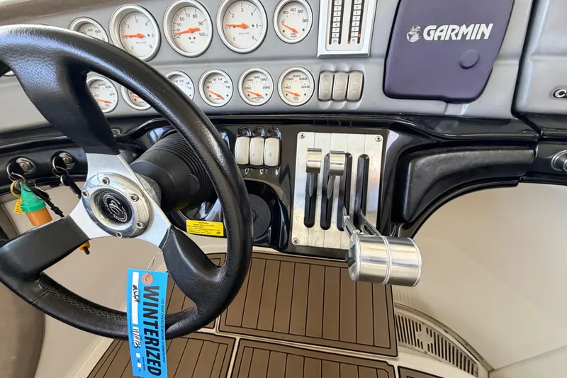 Slide: The Image of Steering wheel and controls of a 2004 Cobalt 343 boat with Garmin navigation. - 44