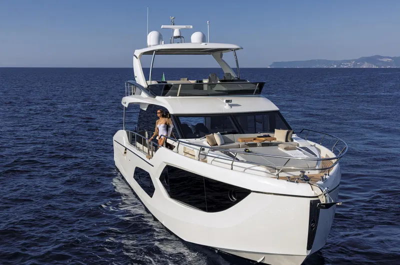 Slide: The Image of Luxury Absolute 60 Fly Co Ownership yacht cruising on open sea, 2025 model. - 2
