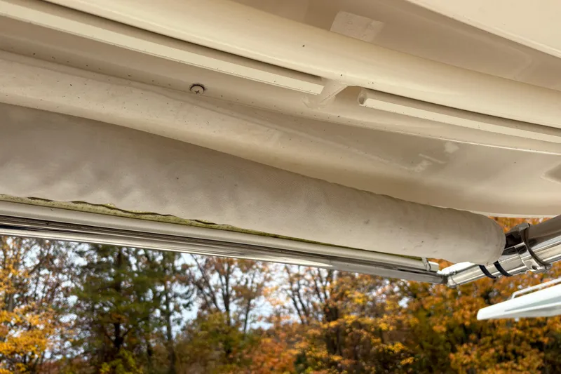 Slide: The Image of 2017 Grady-White Freedom 307 boat canopy detail with autumn trees in background. - 8