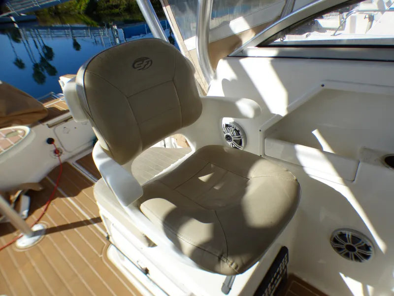 Slide: The Image of Captain's chair on 2016 Sea Fox 256 Voyager boat, beige upholstery, sunny deck view. - 15