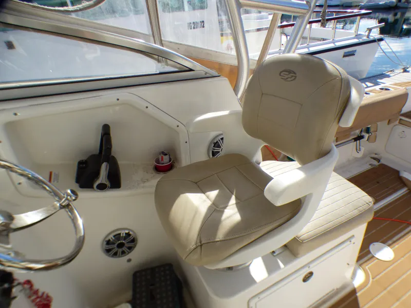 Slide: The Image of Captain's chair on 2016 Sea Fox 256 Voyager boat, featuring beige upholstery and control panel. - 16