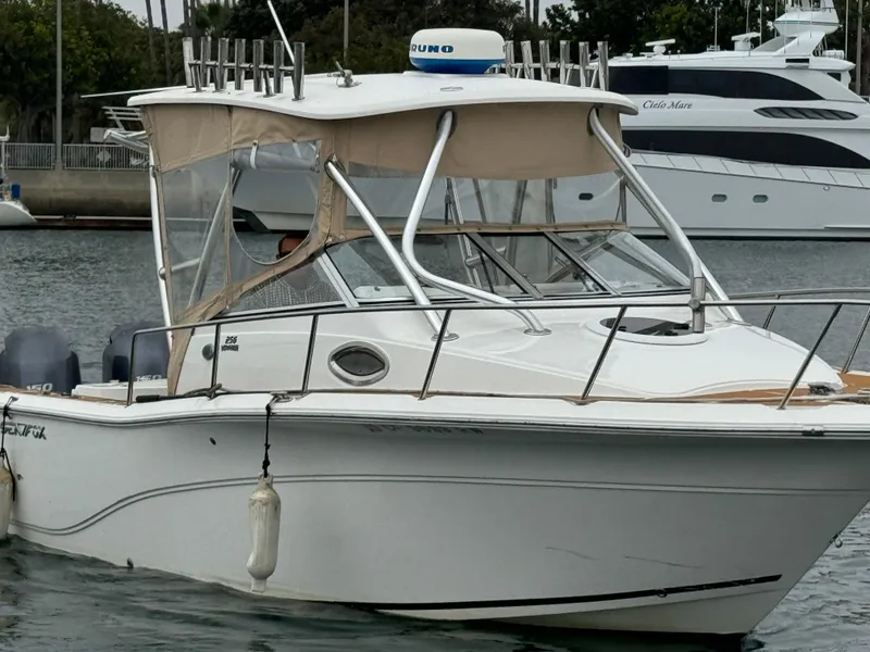 Slide: The Image of 2016 Sea Fox 256 Voyager boat docked in marina, featuring a sleek design and canopy. - 2