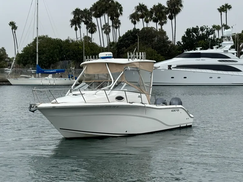 Slide: The Image of 2016 Sea Fox 256 Voyager boat on calm water, surrounded by palm trees and yachts. - 3
