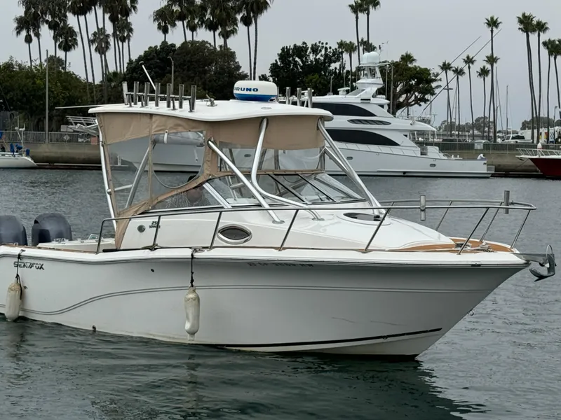 Slide: The Image of 2016 Sea Fox 256 Voyager boat docked in marina with palm trees in background. - 4