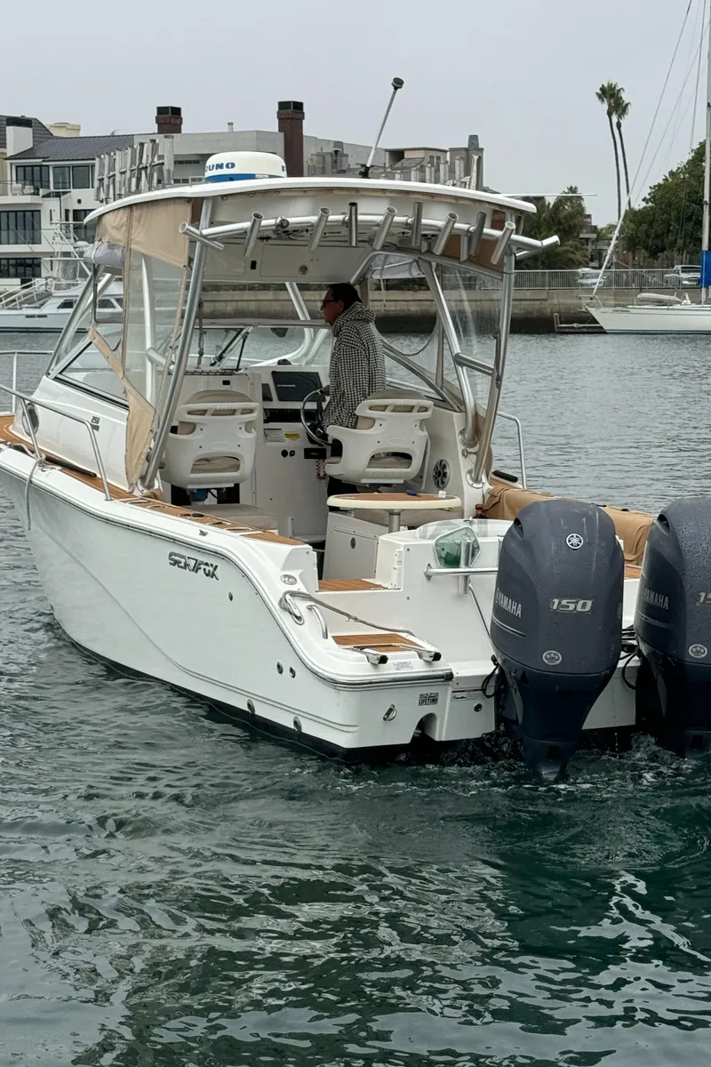 Slide: The Image of 2016 Sea Fox 256 Voyager boat with dual Yamaha 150 engines in a marina setting. - 6