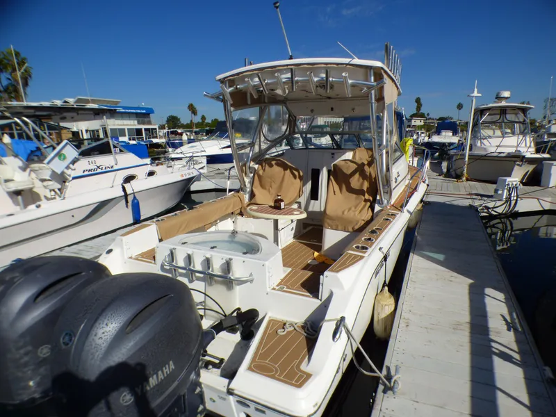 Slide: The Image of 2016 Sea Fox 256 Voyager boat docked with dual Yamaha engines, featuring spacious seating and fishing amenities. - 9