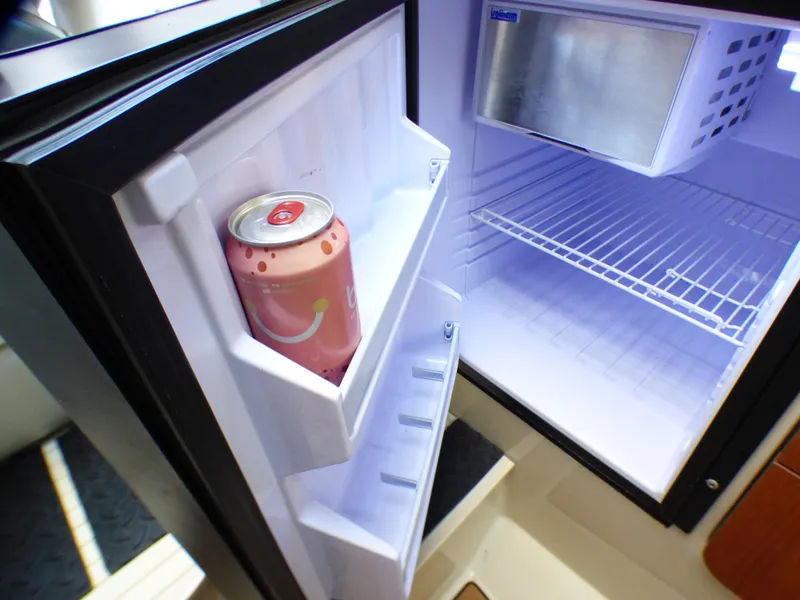 Slide: The Image of Open fridge in 2004 Robalo R265 Walkaround boat with a soda can on the door shelf. - 10