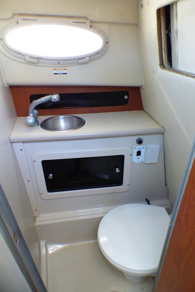 Slide: The Image of 2004 Robalo R265 Walkaround boat bathroom with sink and toilet. - 11
