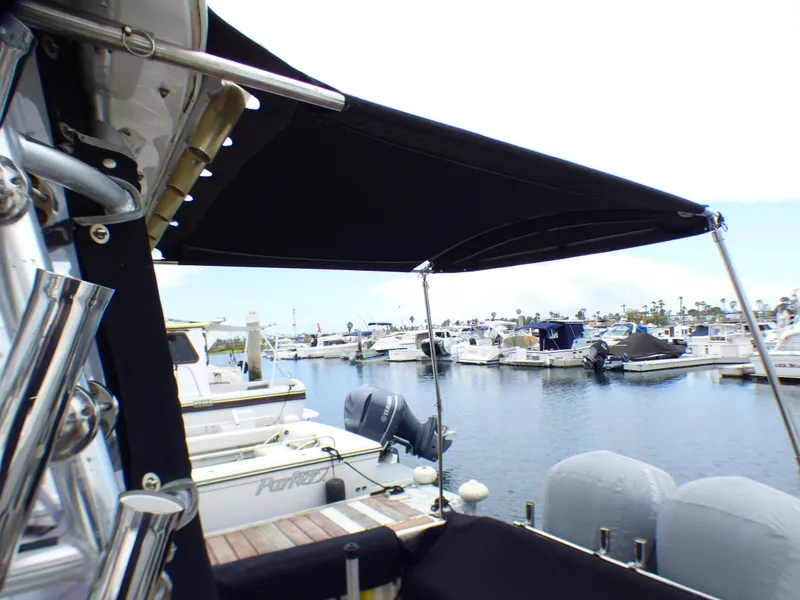 Slide: The Image of 2004 Robalo R265 Walkaround boat docked at marina with black canopy. - 16