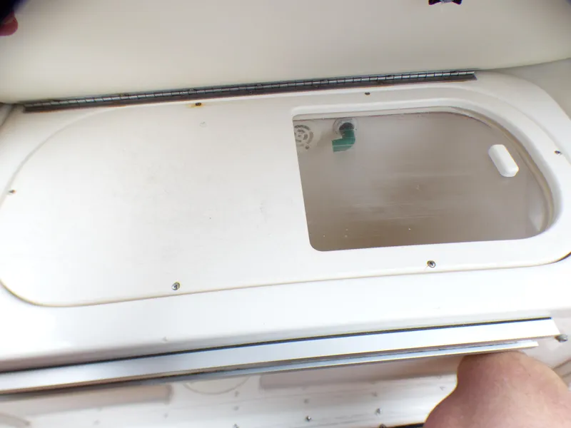 Slide: The Image of 2004 Robalo R265 Walkaround boat compartment with transparent lid and visible latch. - 22