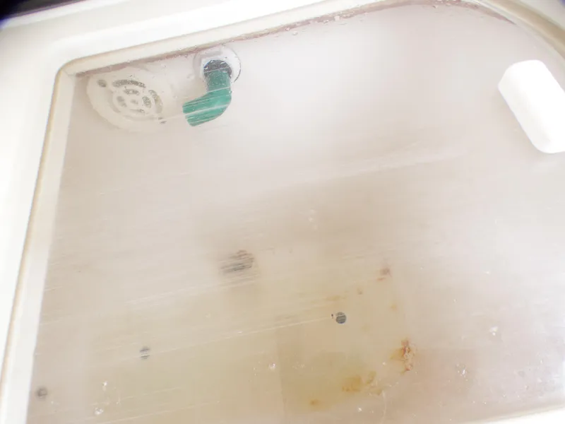 Slide: The Image of 2004 Robalo R265 Walkaround boat compartment with drain and handle. - 23