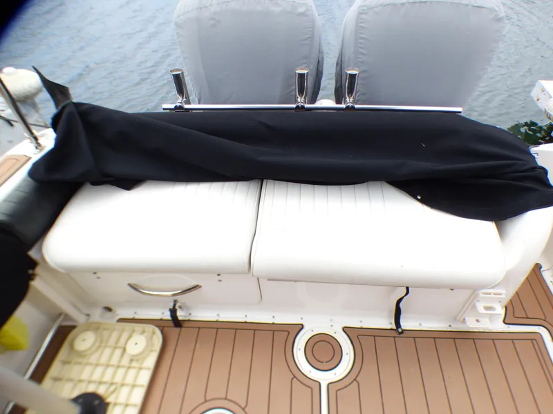 Slide: The Image of 2004 Robalo R265 Walkaround boat interior with cushioned seating and protective cover. - 24